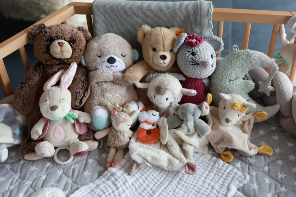 Bunte Kuscheltiere im Laufstall
